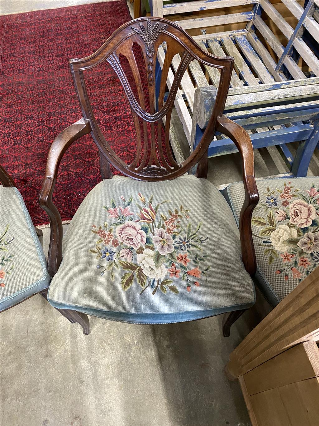 A set of six Hepplewhite style mahogany shield back dining chairs with tapestry drop in seats (two with arms)